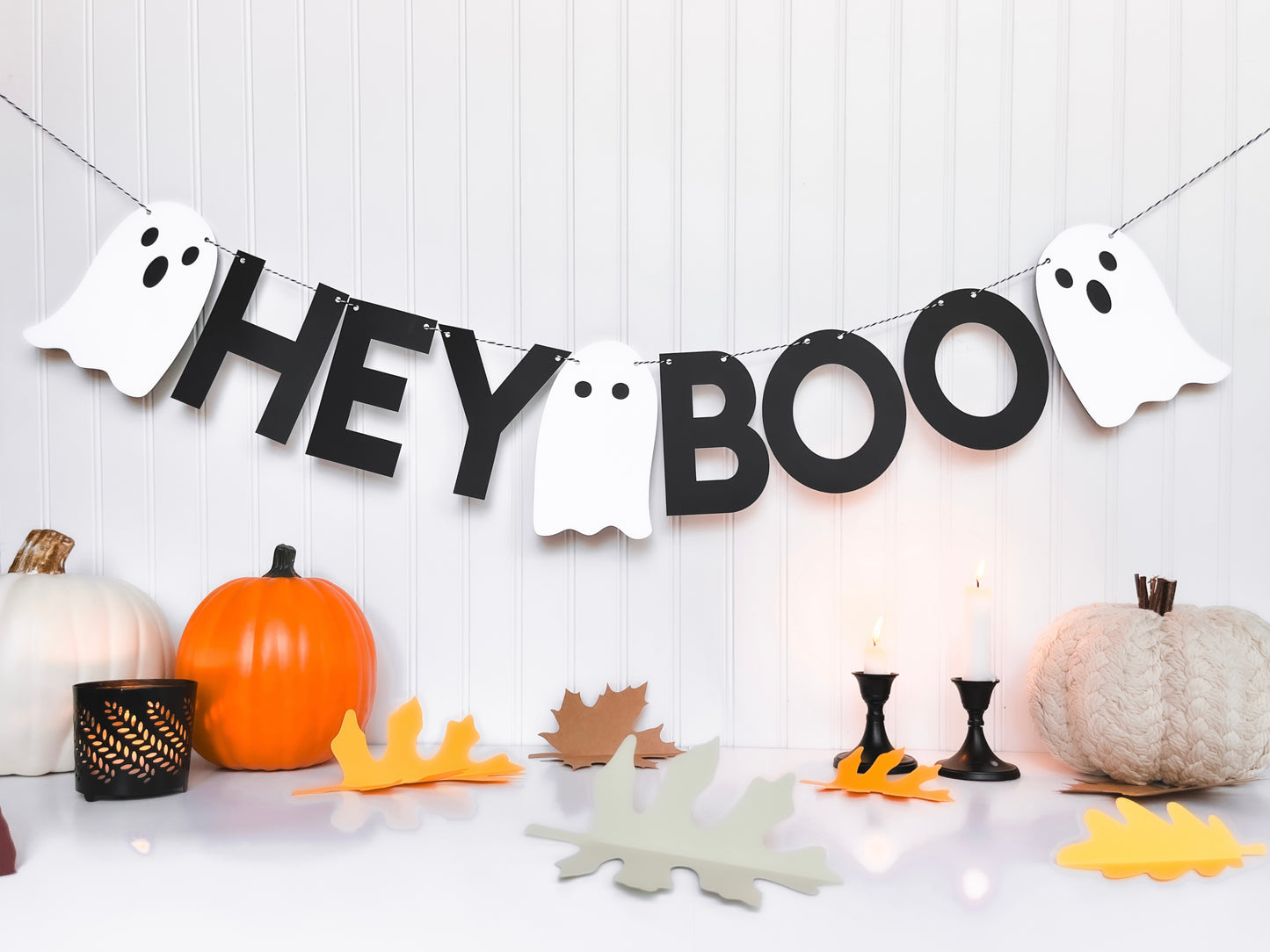 Paper Halloween Banner saying "Hey Boo" in black letters with three cute white ghosts on black & white baker's twine string.. 