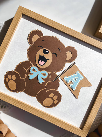 Framed picture of a cartoon bear with a bow and letter 'A' on a white background