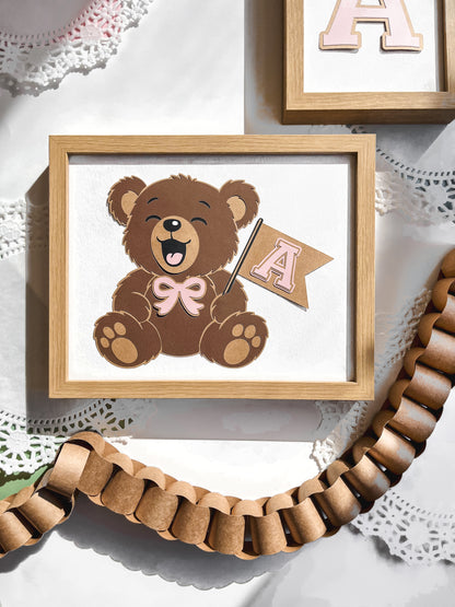 Framed picture of a teddy bear holding a letter 'A' flag on a lace background
